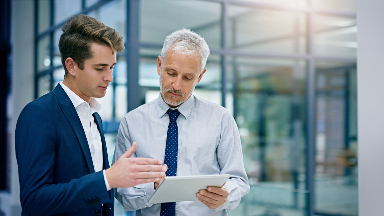 Two male executives checking on the tablet device
