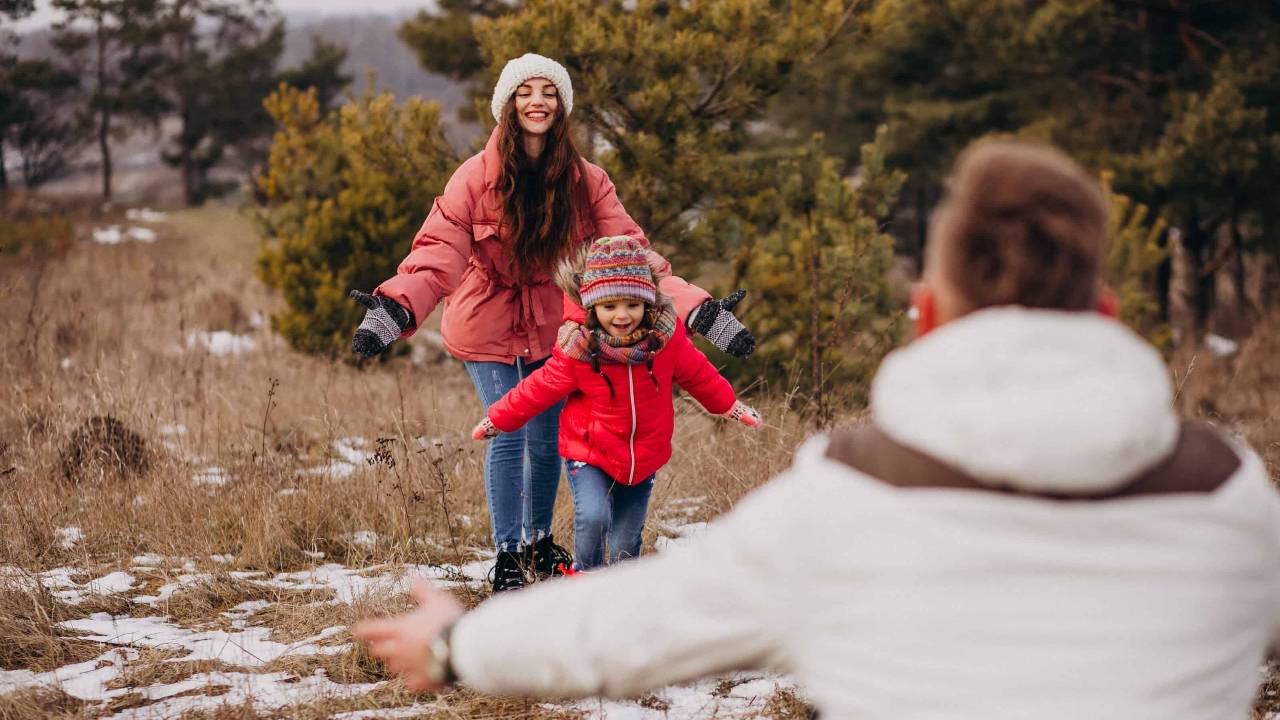 young family together walking forest winter time